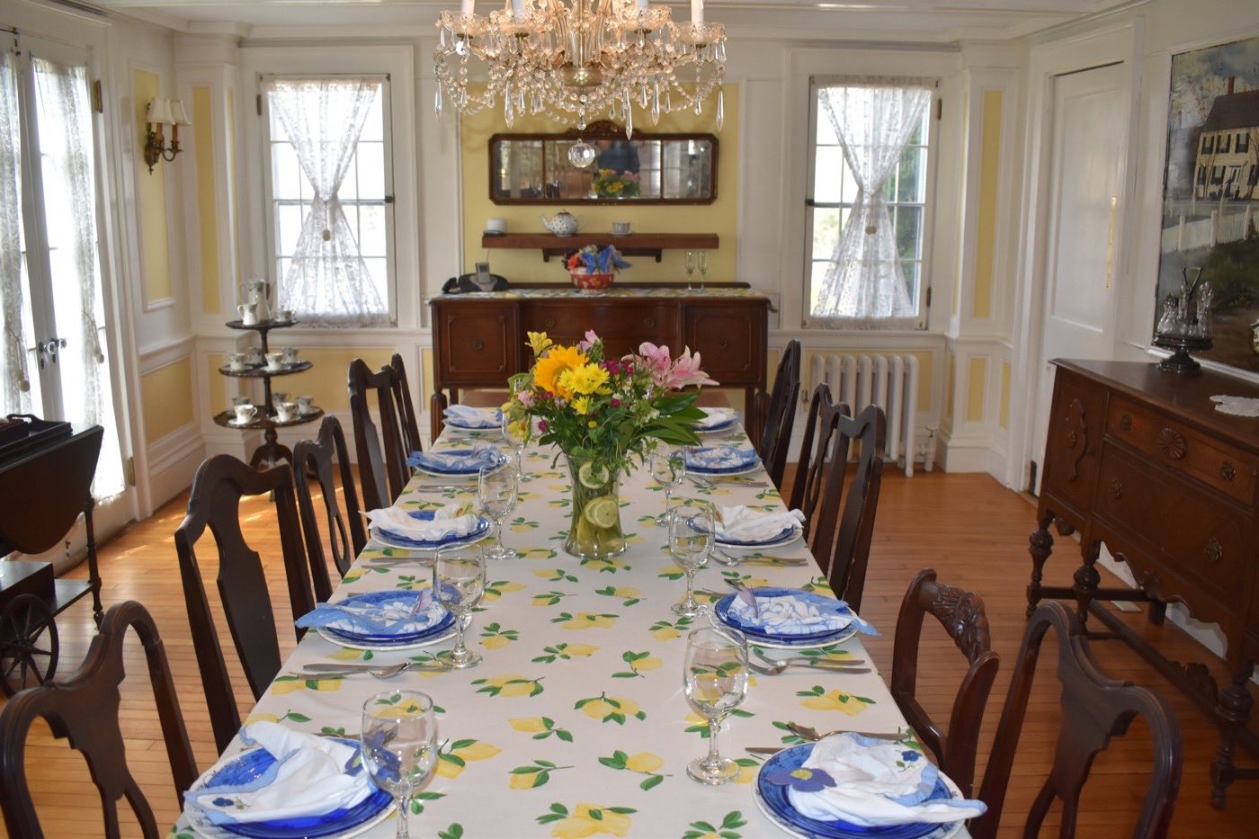 The Inn's dining room, one long table set for breakfast under a chandelier.